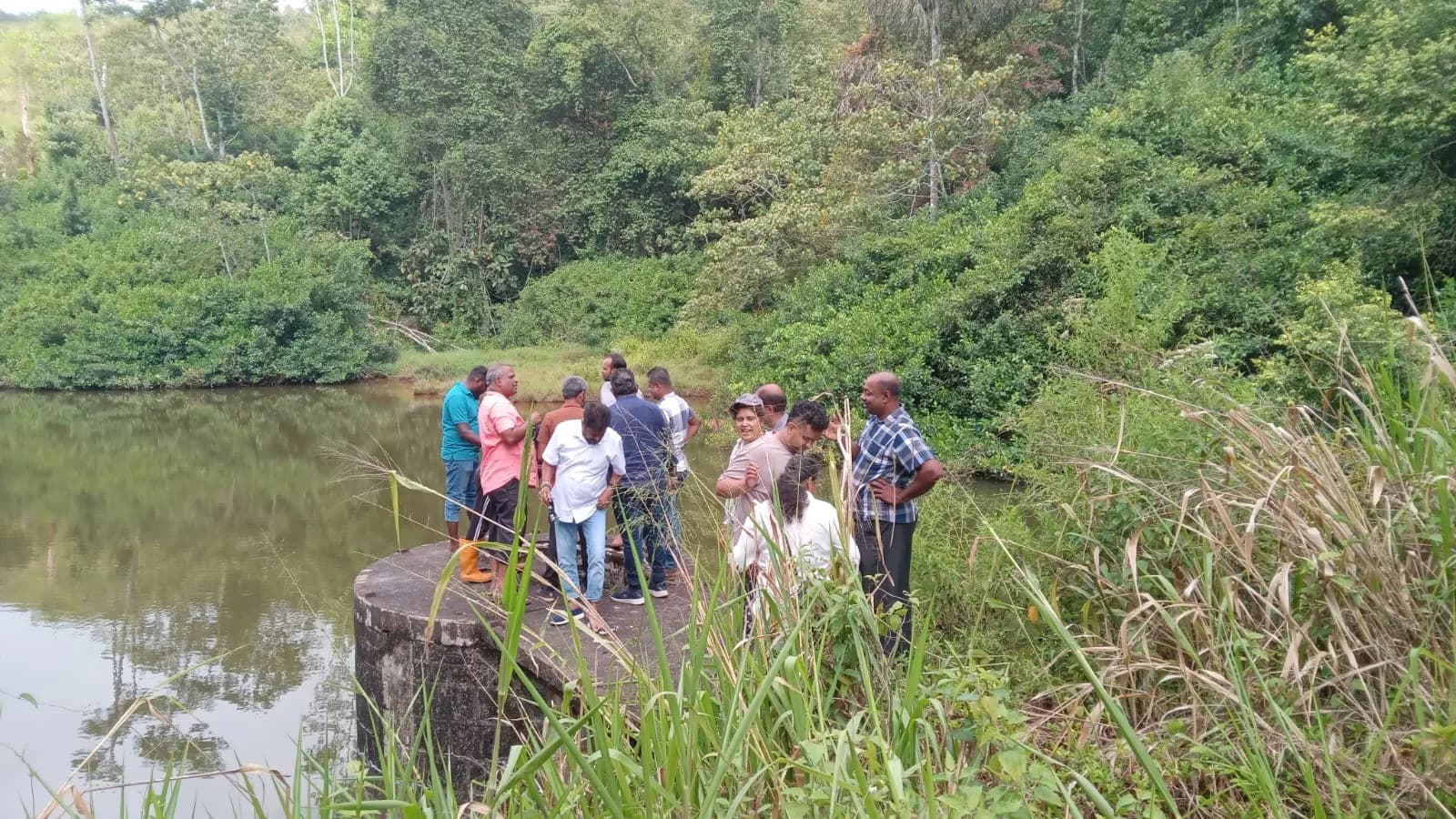 Living Heritage team inspecting a reservoir surrounded by forest